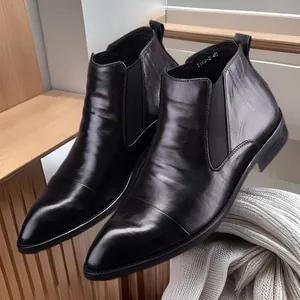 Stylish men's black pointed-toe leather Chelsea boots with elastic sides in a sleek mid-top design.