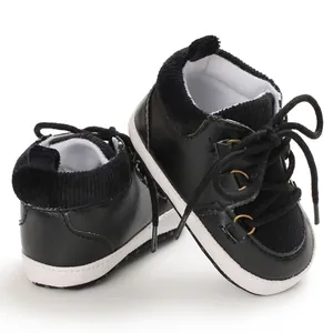 Gros plan sur des chaussures de marche pour bébé noires avec semelles blanches souples