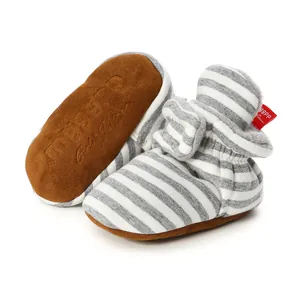 Detailed view of striped knit baby booties featuring soft brown soles and warm fleece lining