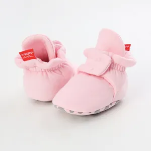 Close-up of pink baby sock-shoes featuring soft non-slip dotted soles and Velcro straps