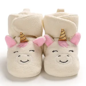 Dettaglio delle comode scarpe da neonato unicorno in peluche bianco con corna dorate.