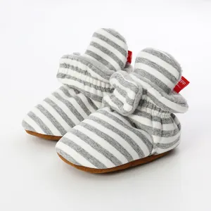 Macro detail of striped knit baby booties featuring a soft sole and warm plush lining inside.