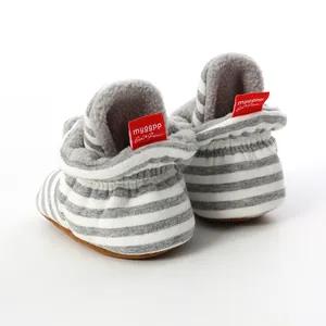 Close-up view of striped knit baby booties with soft soles and warm grey fleece lining