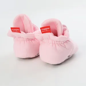 Detail of soft sole pink baby walking shoes featuring elastic ankle and red heel label