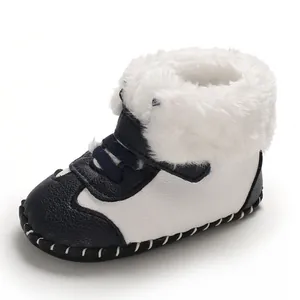 Nahaufnahme von dunkelblauen und weißen Baby-Winterstiefeln mit dickem Kunstpelz