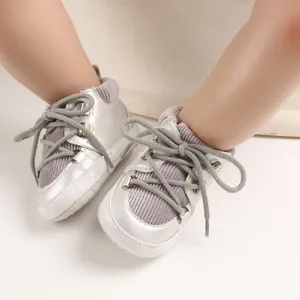 Gros plan sur des chaussures bébé argentées avec semelles souples et détails en velours violet