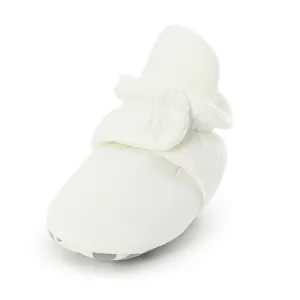 Detailed view of an off-white soft sole baby walking bootie with a secure adjustable strap.