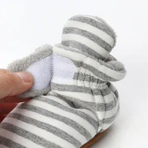 Close-up of a soft striped baby bootie featuring warm fleece lining and a functional Velcro strap