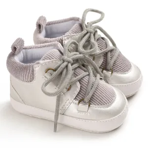 Vue détaillée des chaussures de marche pour bébé en velours côtelé argenté et gris.