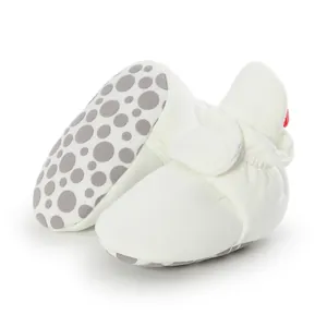 Detail of white soft sole baby walking shoes with anti-slip grey dots.
