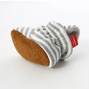 Close-up of striped knitted baby booties with soft brown sole and warm fleece lining