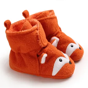 Primo piano di scarpine neonato volpe arancione con morbida texture in pile e strappo