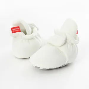 Close-up of soft white cotton baby sock shoes with non-slip soles