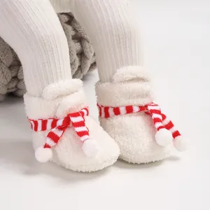 Close-up detail of white plush Christmas baby boots with red striped scarf decor