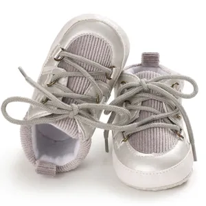 Vue détaillée de chaussures bébé argentées avec semelles souples et velours côtelé gris.