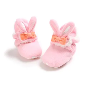 Detailweergave van zachte roze fleece babyschoentjes met konijnenoren en strik