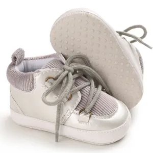Gros plan de chaussures de bébé argentées avec détails en velours et semelles souples