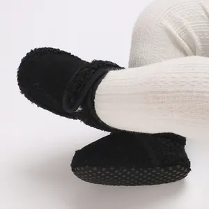 Close-up of black baby winter snow boots with soft sole and warm fuzzy fleece lining
