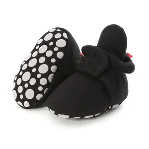 Close-up of black baby sock shoes with anti-slip dotted soft sole for toddlers