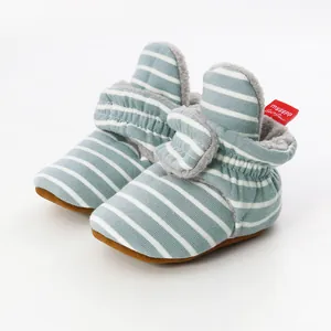 Detailed view of striped knitted baby booties with soft fleece lining and rubberized sole