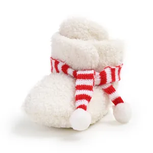 Close-up of white plush baby bootie with a red striped scarf decorative detail
