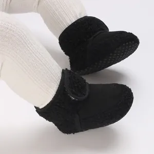 Macro view of black fuzzy baby snow boots with soft soles designed for infant warmth