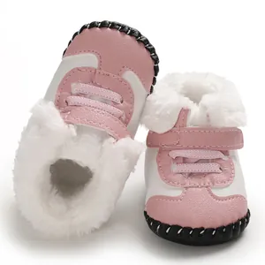 Detailaufnahme von rosa-weißen Baby-Schneestiefeln mit dickem Plüschfutter und Gummisohle