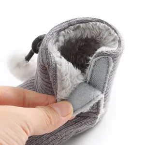 Gros plan montrant la doublure en polaire douce et le velcro des bottes bébé grises
