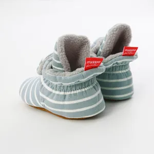 Detailed view of blue striped baby booties showing soft fleece lining and red tag