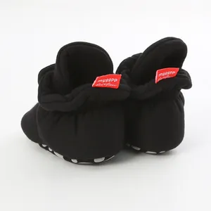 Close-up back view of black baby walker shoes with soft non-slip soles and red heel labels