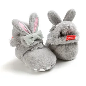 Detailopname van pluche konijnen babyschoentjes met zacht kunstbont en een grijs strikje.