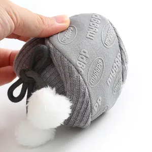 Gros plan de bottes souples pour bébé avec pompons blancs montrant flexibilité et confort