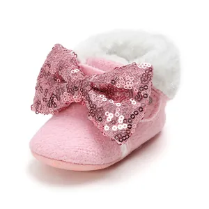 Detailansicht von rosa Baby-Lauflernschuhen mit Paillettenschleife und Kunstpelzbesatz