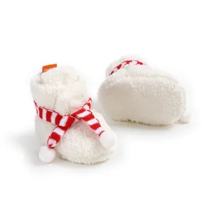 Detailed view of plush baby booties featuring a cozy red and white striped scarf accent