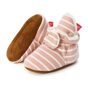 Detail view of pink striped knitted baby booties with soft soles and warm fleece lining