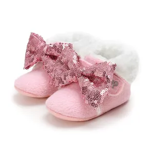 Rosa Baby-Winterschuhe mit weicher Sohle, großer Pailletten-Schleife und weißem Fellrand