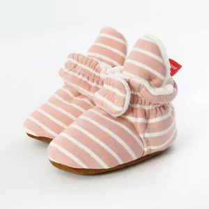 Detailed view of pink and white striped baby booties with a soft warm fleece lining