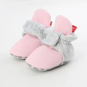 Detailed macro view of pink and grey infant soft-sole booties designed for learning walking.
