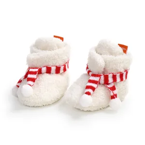 Close-up detail of soft white fleece baby booties with red and white striped scarf