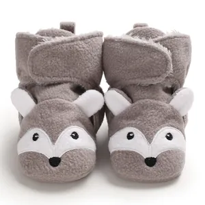 Dettaglio scarpine neonato grigie a forma di volpe in morbido pile con velcro.