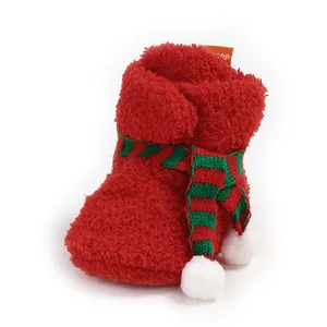 Detailed view of red plush Christmas baby bootie with green striped scarf