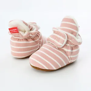 Detailed view of pink striped baby booties with warm fleece lining and soft soles.