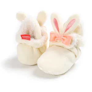 Detail van pluche baby-schoentjes met roze konijnenoren en een strikje