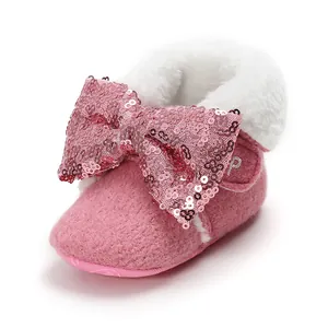 Nahaufnahme eines rosa Babyschuhs mit Fleece-Futter und großer Pailletten-Schleife