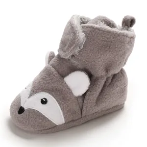 Primo piano di scarpine invernali per neonati a forma di volpe grigia con fodera in peluche