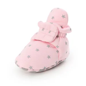 Close-up of soft pink baby walker sock shoes featuring grey star patterns and strap