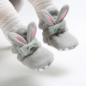 Detailweergave grijze pluche babyschoentjes met konijnenoren en strik