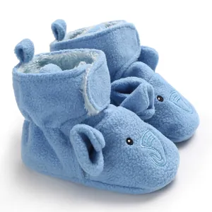 Primo piano di babbucce in pile blu per neonati con ricamo di elefante e chiusura a velcro.