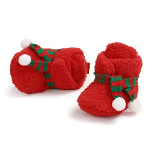Close-up of red plush Christmas baby shoes featuring soft soles and scarf decor