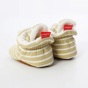 Detail view of striped knit baby booties with soft fleece lining and red heel tags